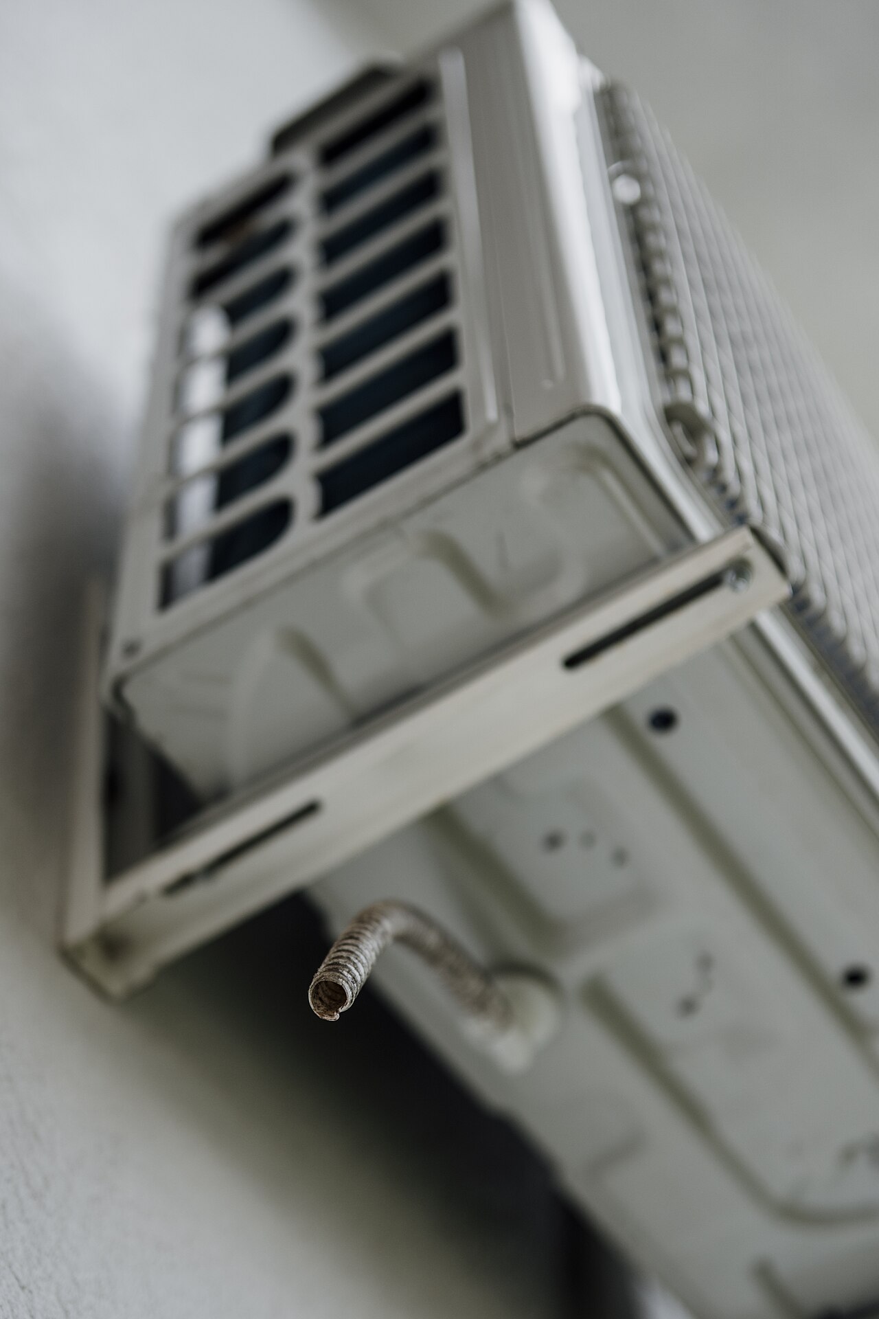 Wall-mounted air conditioning unit with visible cooling pipe in a residential setting